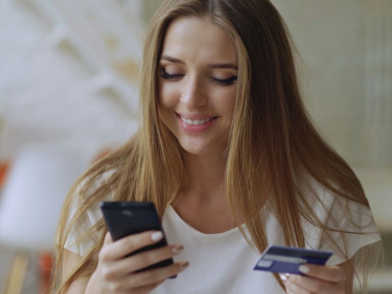 Photo of a lady paying money online using a debit card