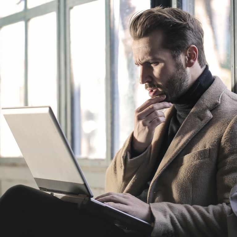 photo of sitting man on a laptop