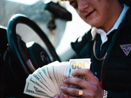 photo of man in car with much cash
