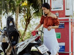 Picture of Thai Girl Pumping Gasoline in to motor bike